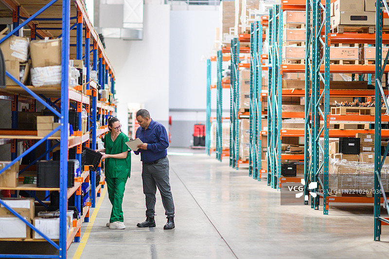 经理和员工在医疗仓库中协作管理库存图片素材