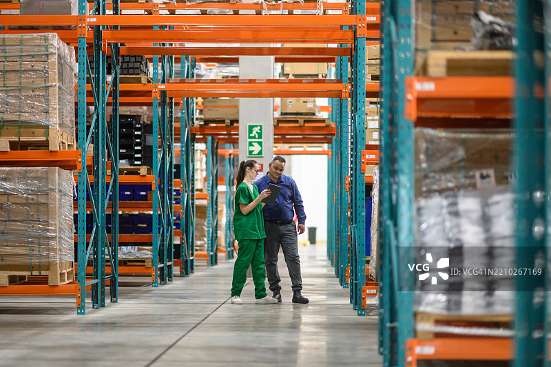 经理和员工在医疗仓库环境中审查库存图片素材