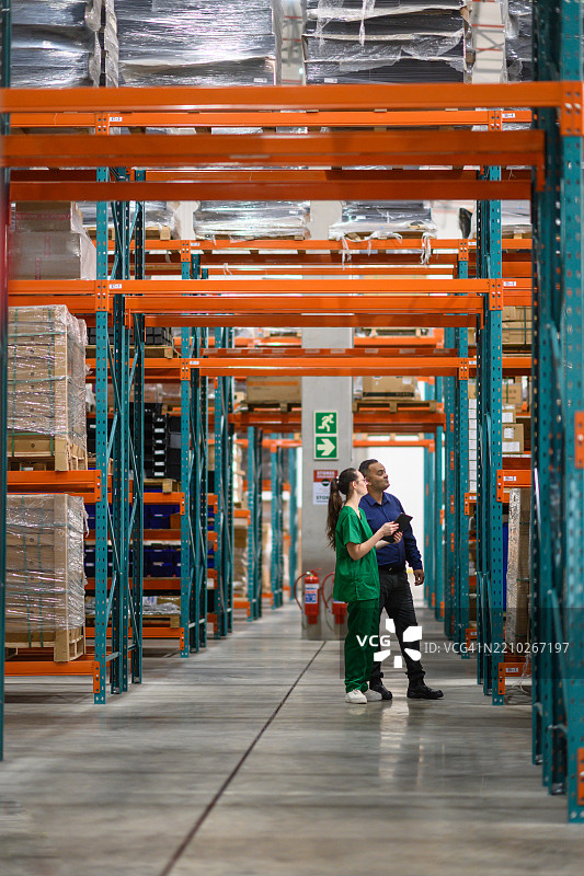 仓库工人在明亮的医疗储存设施中检查库存图片素材