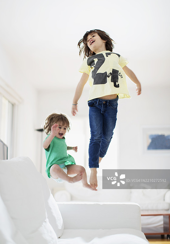 孩子们在明亮的客厅里快乐地跳跃图片素材