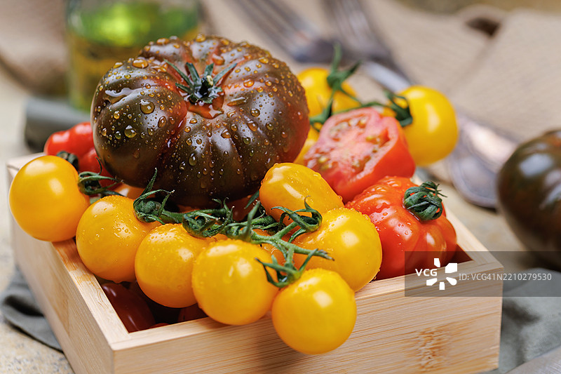 木箱中的番茄与橄榄油和乡村风格的餐具图片素材