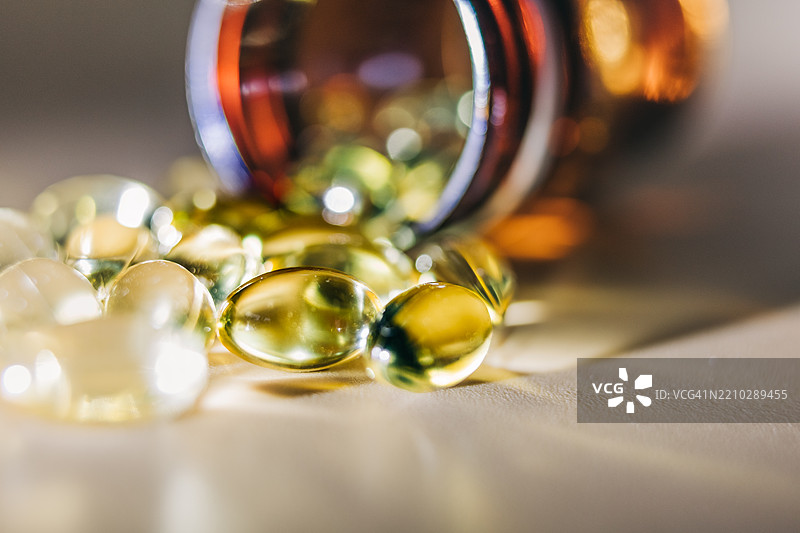 鱼油胶囊从棕色玻璃瓶中洒出图片素材