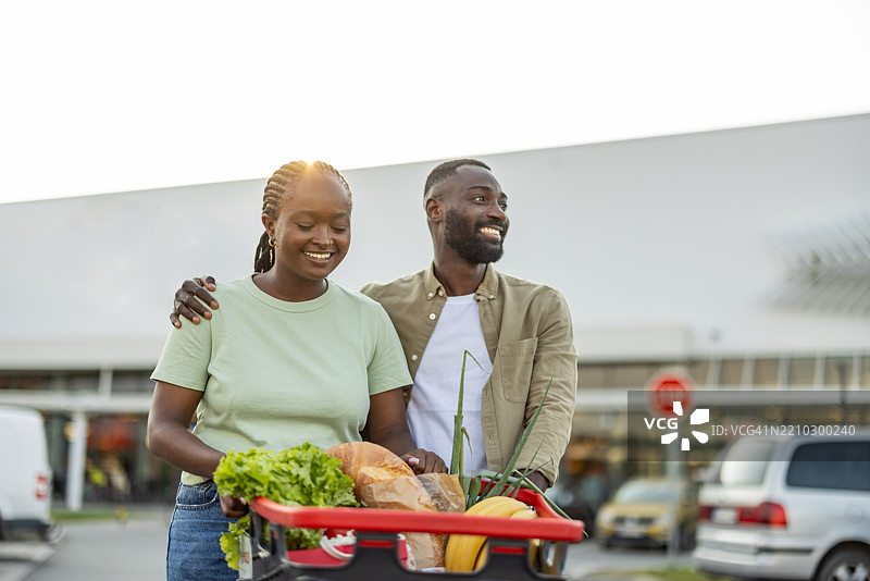 快乐的情侣在超市停车场购物图片素材