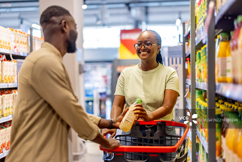 在超市过道中购物者之间的友好互动图片素材