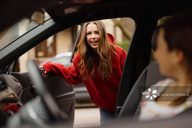友好的年轻女性微笑着打开车门图片素材