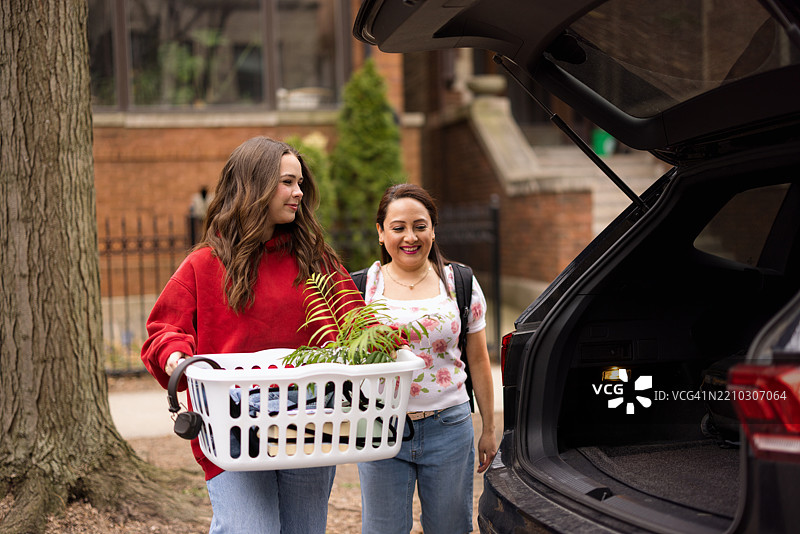 朋友们在阳光明媚的户外装载家居物品到车上图片素材