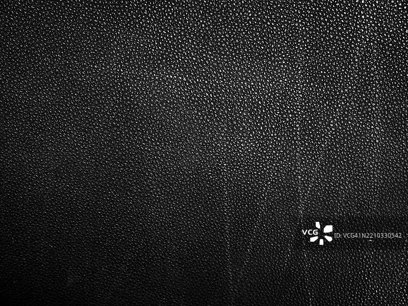 黑色、有纹理和氧化的皮革特写（磨损痕迹）。阳光与阴影。黑白色调。法国巴黎。图片素材