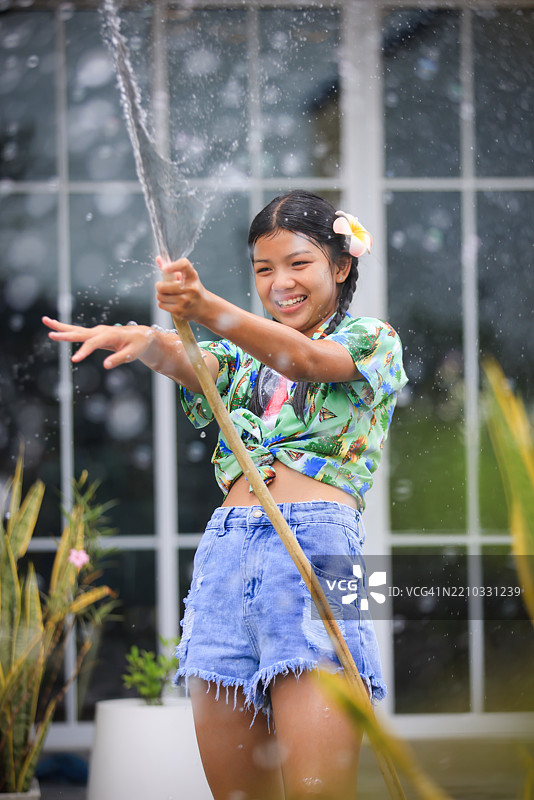 可爱的亚洲女孩穿着夏季宋干节服装，手持水枪庆祝宋干节，泰国新年。图片素材