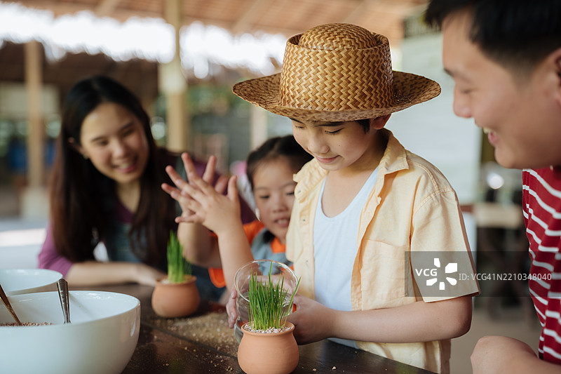 家庭志愿者快乐地为更绿色的环境种植一棵幼树图片素材