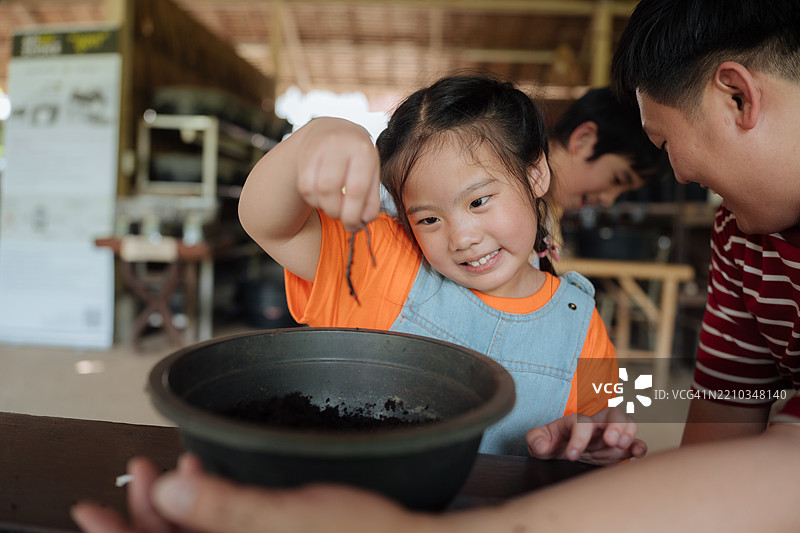 家庭志愿者快乐地为更绿色的环境种植一棵小树。图片素材
