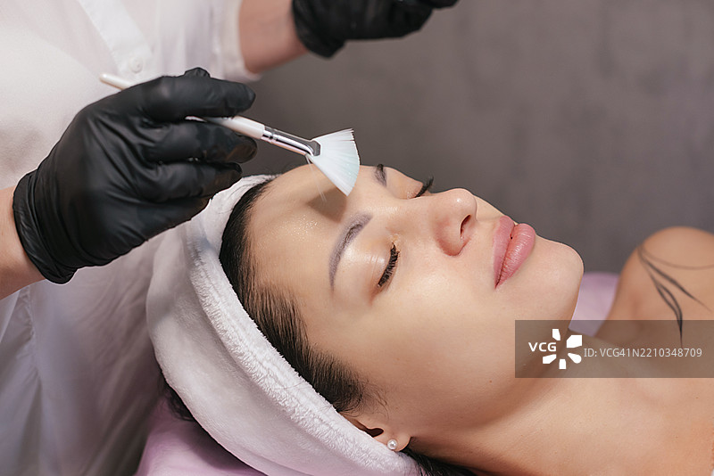 在美容院为顾客涂抹面霜图片素材
