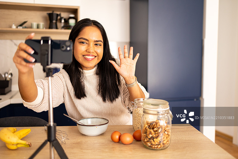 美丽的印度女性博主正在为她的美食频道录制和直播视频。图片素材