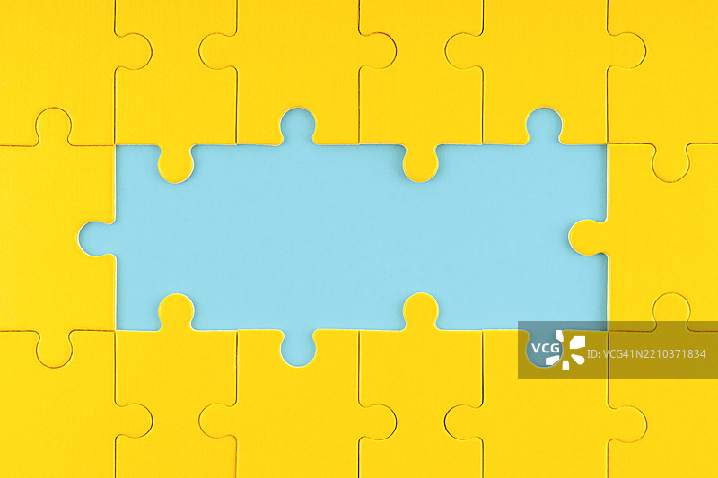 蓝色背景上的缺失黄色拼图图片素材
