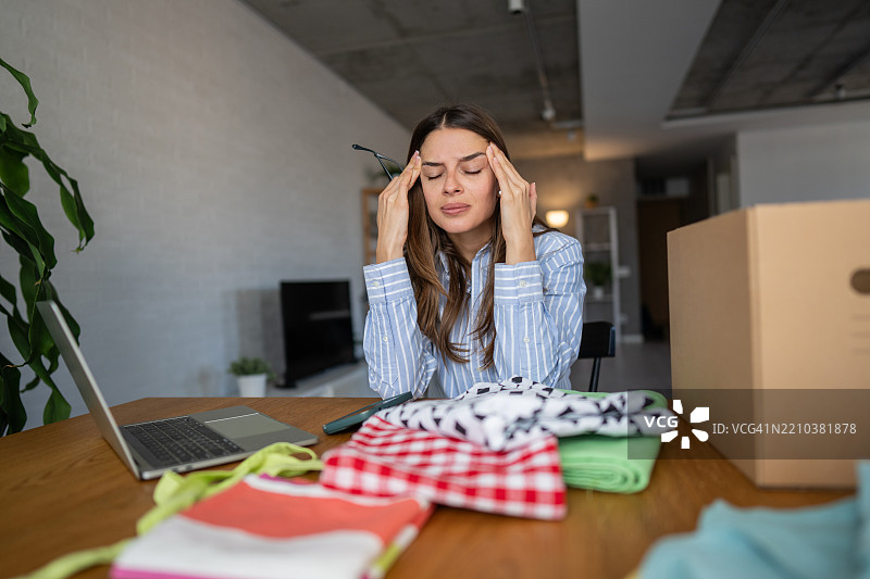 在家工作的压力女性企业家按摩太阳穴图片素材