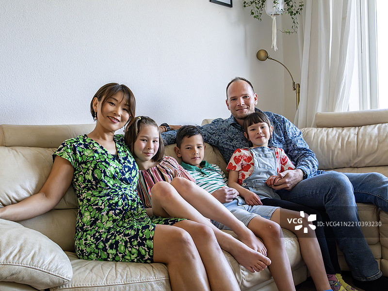 快乐的多种族家庭在家中。图片素材