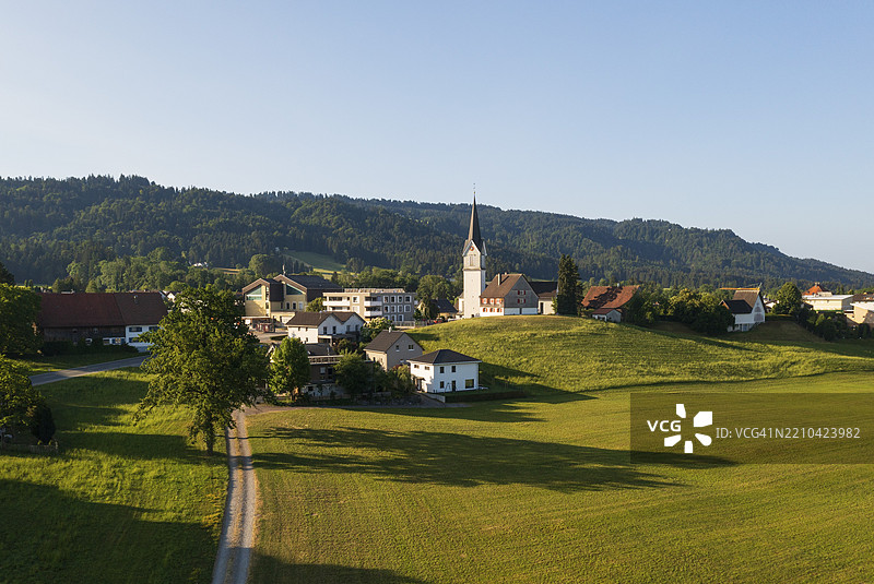 无人机图像，俯瞰奥地利福拉尔贝格州霍亨维勒村及其教区教堂，欧洲图片素材