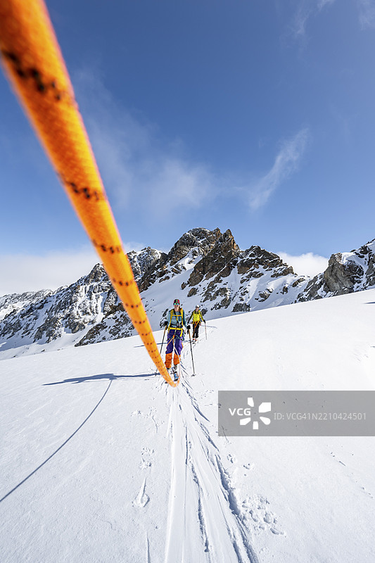 绳索队伍在攀登皮兹凯什山峰途中,于瓦德雷特达波尔切贝拉冰川上进行滑雪登山,冬季山地景观,高山之旅,滑雪登山路线,阿尔布拉阿尔卑斯山,拉绍阿尔卑斯山,格劳宾登州,瑞士东部,瑞士,图片素材