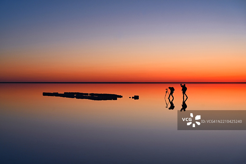 在埃尔顿湖的红色日落中，摄影师的剪影图片素材
