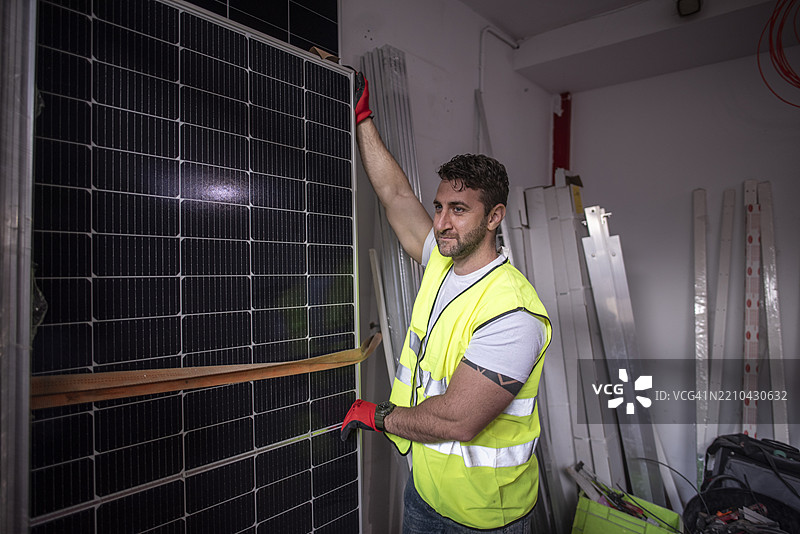 太阳能面板工人在仓库中准备安装面板。图片素材