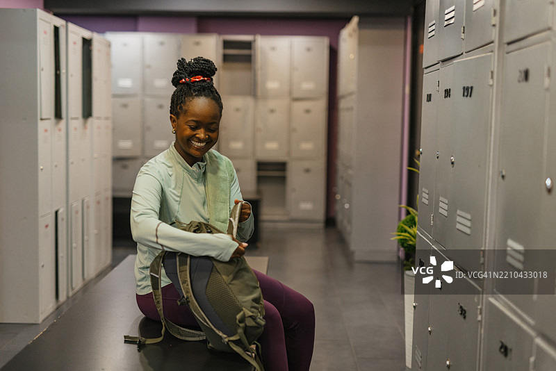 女性在健身房更衣室准备离开锻炼后图片素材