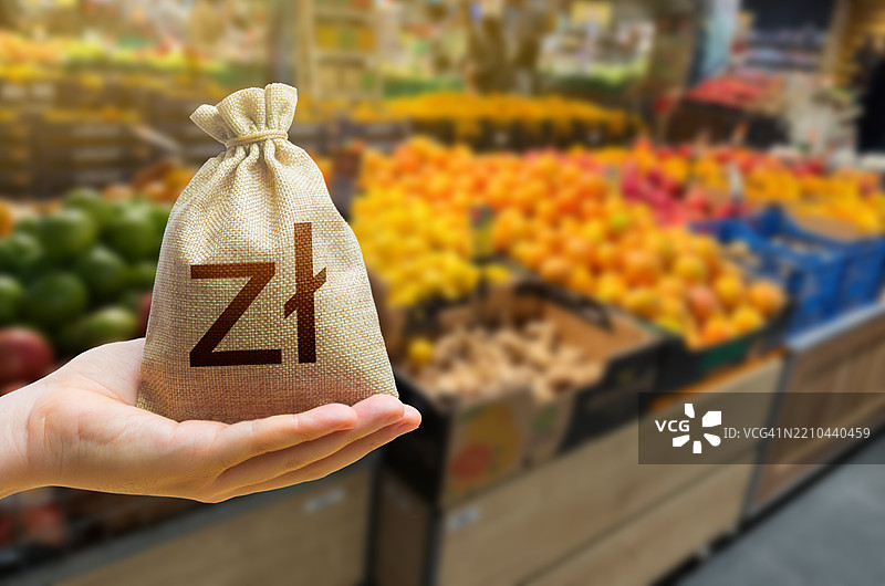 波兰兹罗提钱袋放在杂货店柜台背景上，柜台上有新鲜的有机蔬菜和水果。商品和食品成本的概念，杂货组合，进出口。图片素材