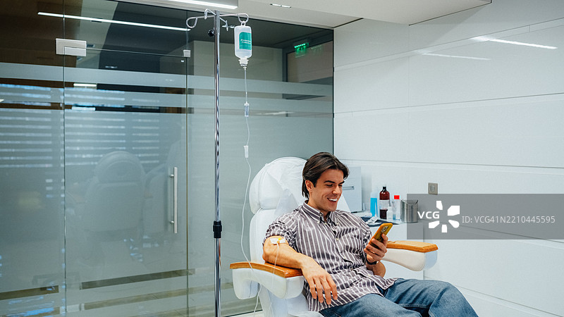 男子在美容诊所接受静脉维生素治疗图片素材