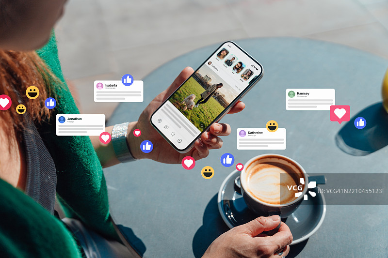 女性从肩后视角在社交媒体平台上通过智能手机发表评论并点赞图片素材