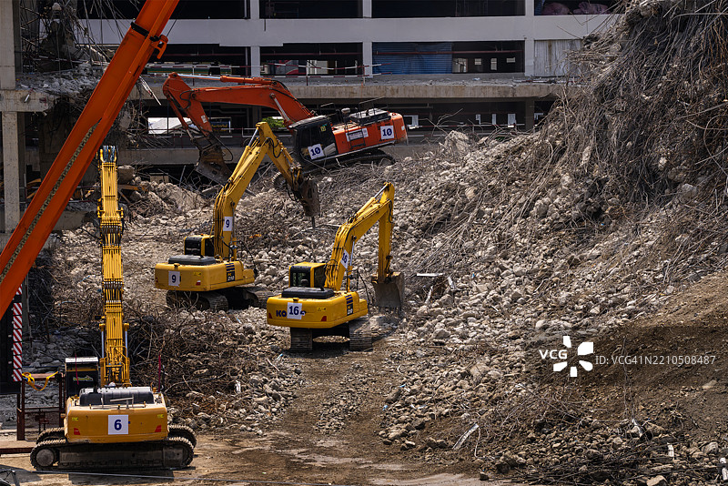 大型建筑拆除现场的重型机械作业图片素材