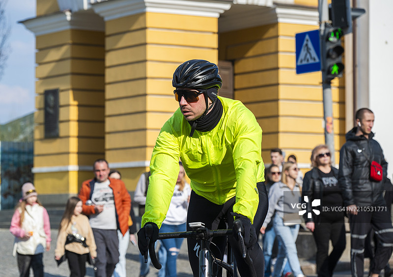 骑自行车的人在2025年4月的基辅波迪尔地区的萨哈伊达奇诺霍街上穿行，街道热闹非凡。图片素材