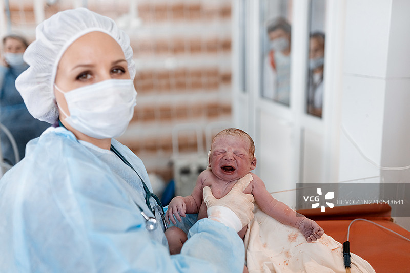 医疗专业人员在医院接生后抱着新生儿图片素材