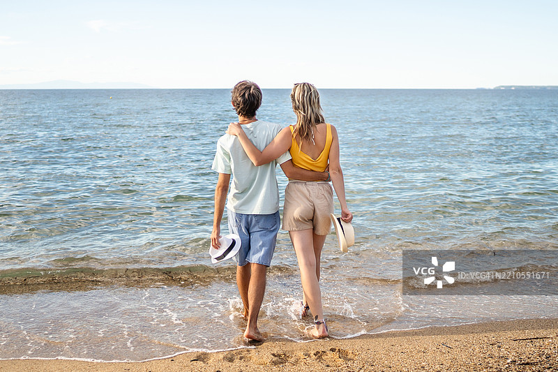 情侣在海滩上手牵手，享受夏日假期图片素材