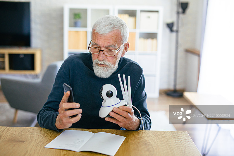 老年人尝试安装他的IP安全摄像头图片素材