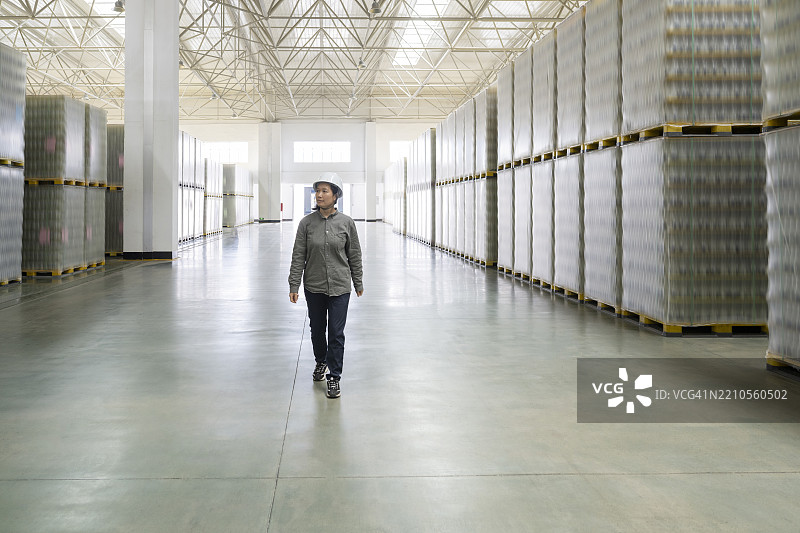 一名女性工人在大型玻璃产品仓库工作图片素材