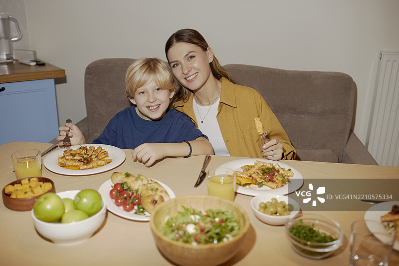 母亲和儿子在家一起享受晚餐图片素材