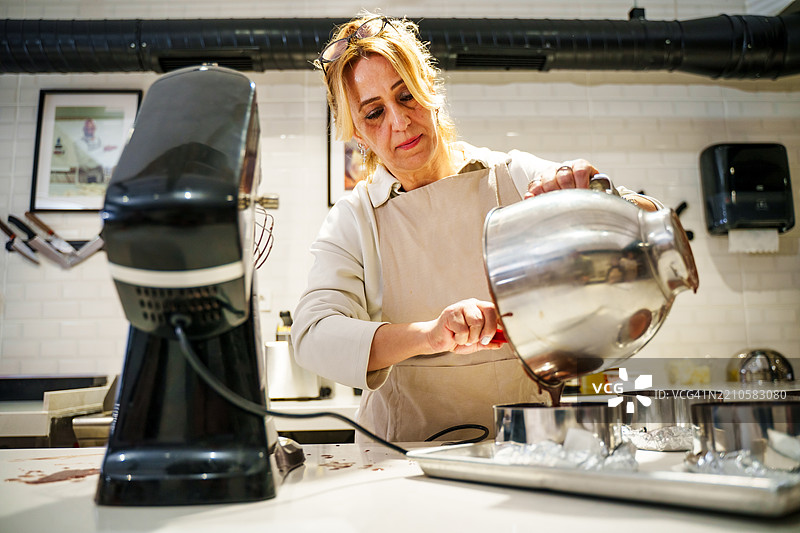 人们在现代厨房中装饰蛋糕 - 烘焙课程或工作坊图片素材