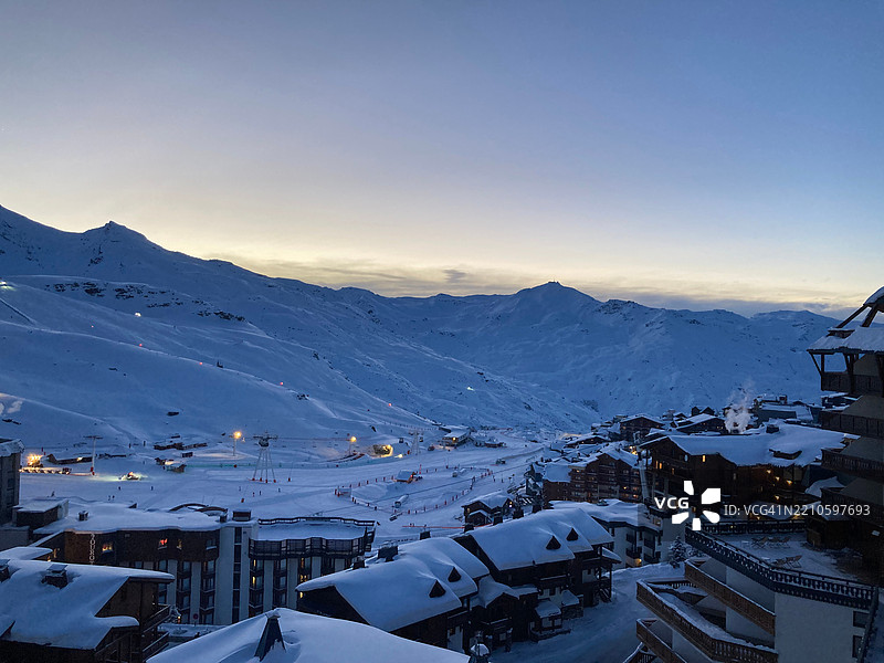 黄昏时分的瓦尔托伦斯，山间日落与灯火辉煌的滑雪小屋图片素材