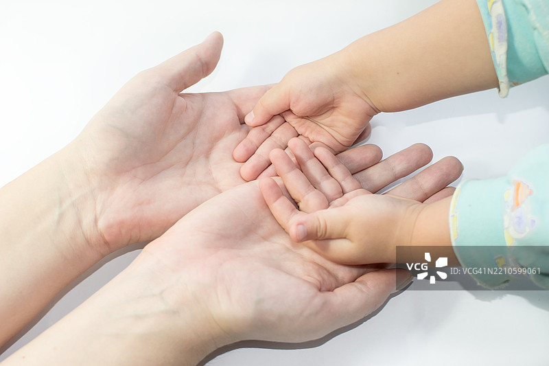 母亲的手小心翼翼地握着孩子的手掌图片素材