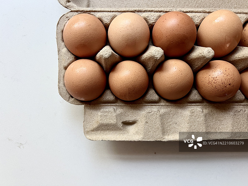 早晨阳光下白色台面上的新鲜鸡蛋纸箱图片素材