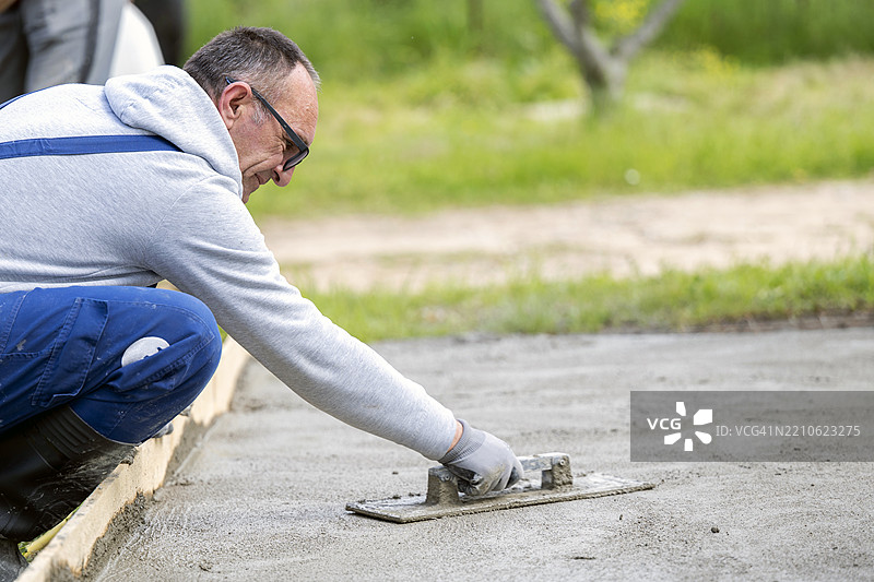 建筑工人 - 男子用抹子完成混凝土工作和抹灰工图片素材