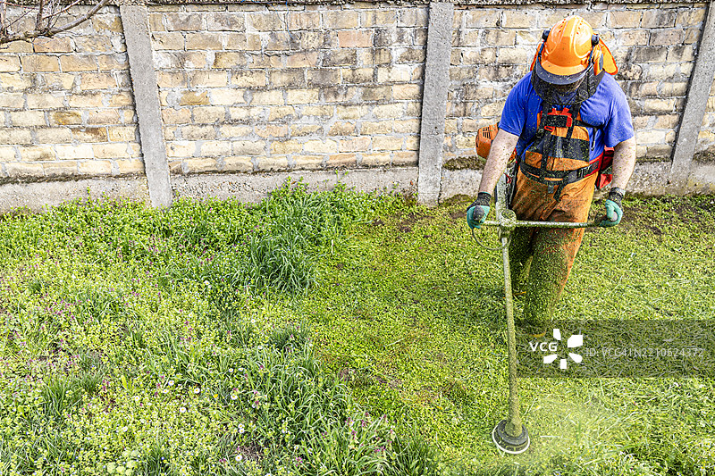 草坪维护，使用绳锯修剪草坪图片素材