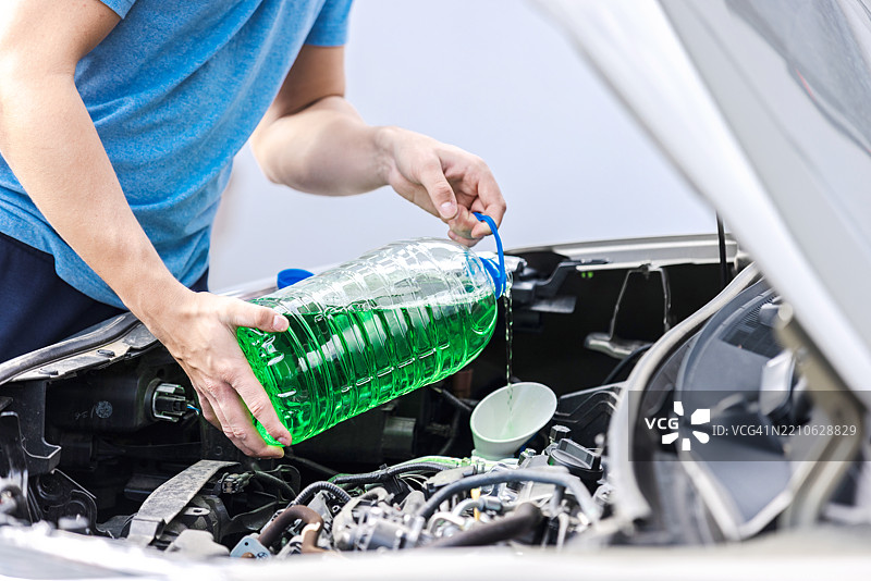向散热器中添加汽车防冻液以进行发动机维护图片素材
