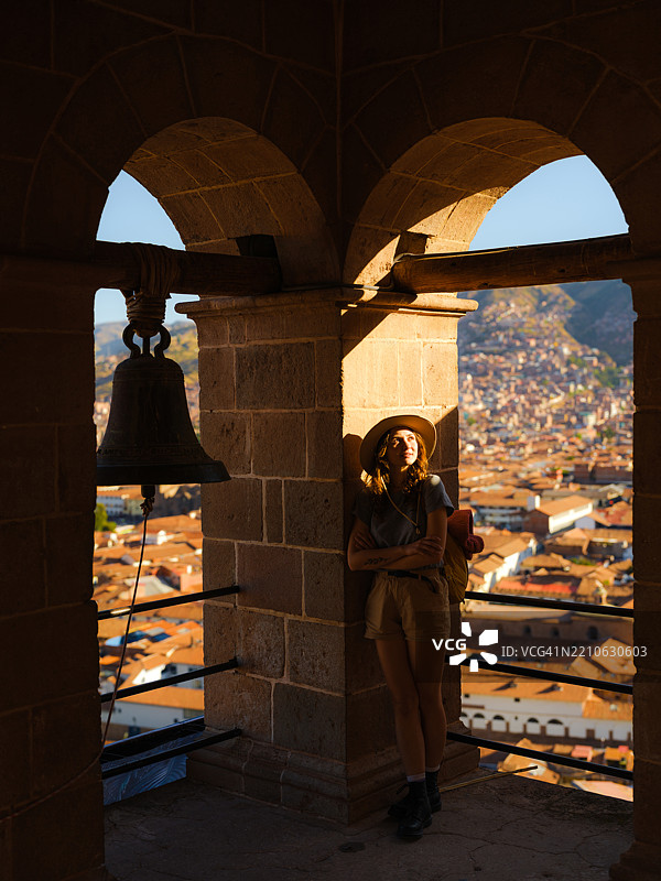 在秘鲁库斯科老城的钟楼中，女人俯瞰风景。图片素材