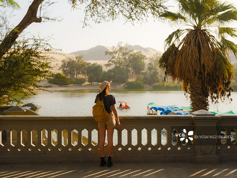 在秘鲁华卡奇纳绿洲湖边的女人图片素材