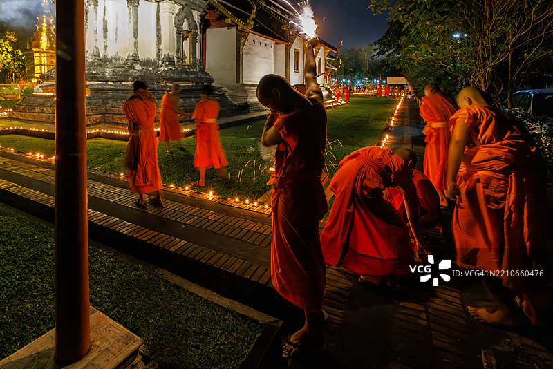 佛教僧侣在泰国清迈省的帕辛寺点燃烟花。图片素材