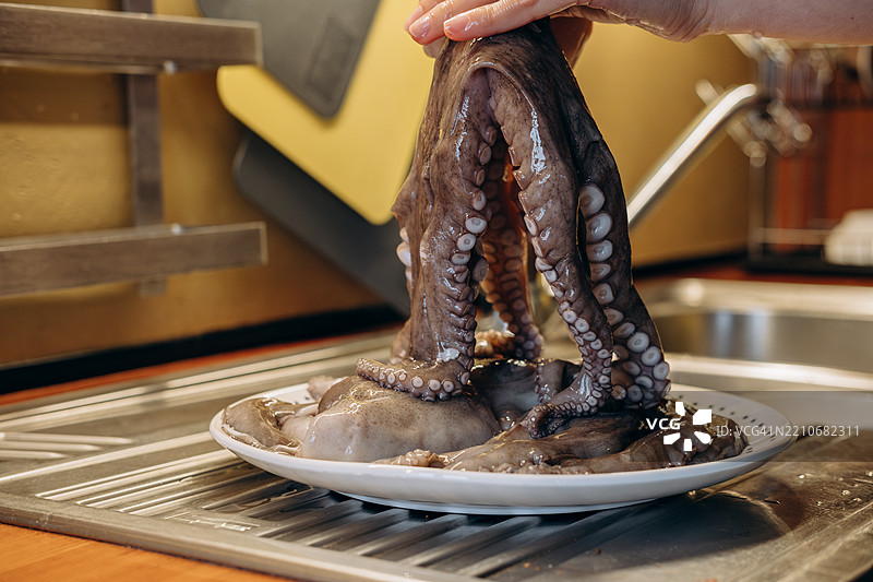 特写镜头：一位女性正在为午餐烹饪新鲜章鱼图片素材