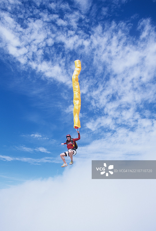 女跳伞者在自由落体中与彩带一起飞翔图片素材