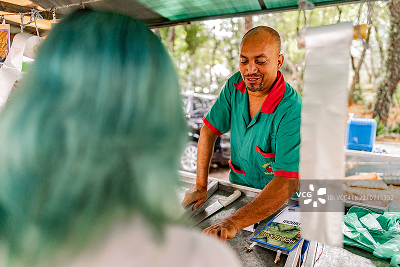 摊贩在街市上帮助顾客图片素材