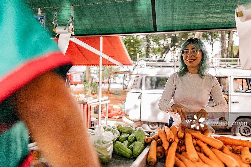 中年女性在街市挑选胡萝卜图片素材