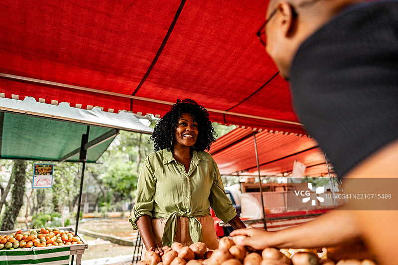 中年女性在街市挑选土豆图片素材