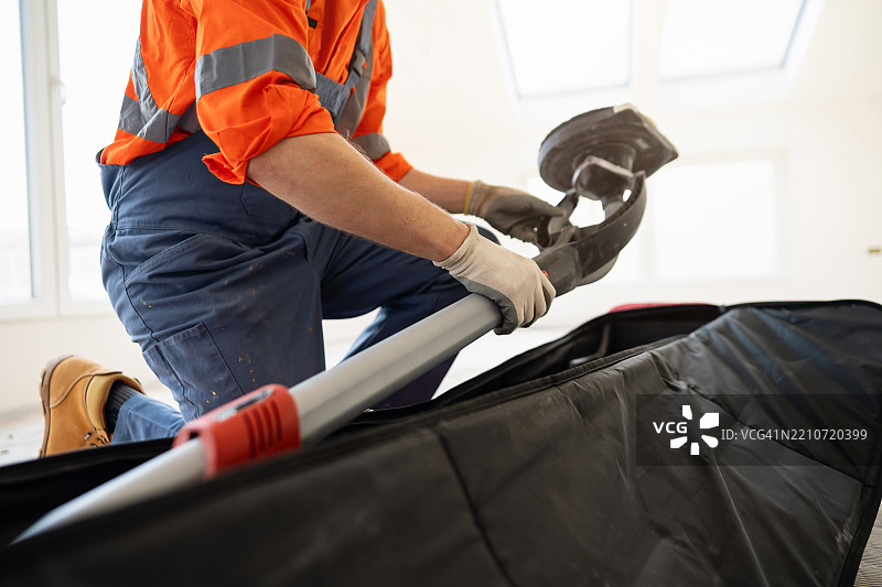 一位建筑专业人士正在准备长颈鹿墙面打磨机图片素材